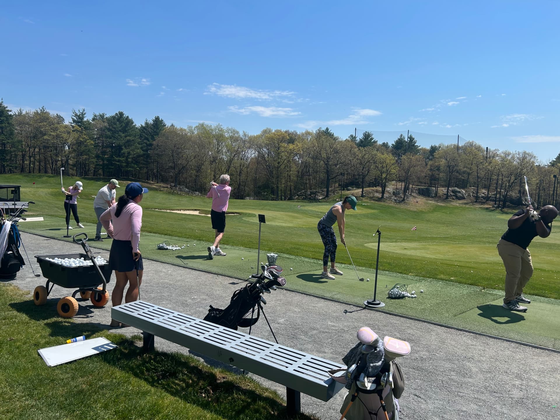 Adult golfers in a small-group clinic on the KOHR driving range