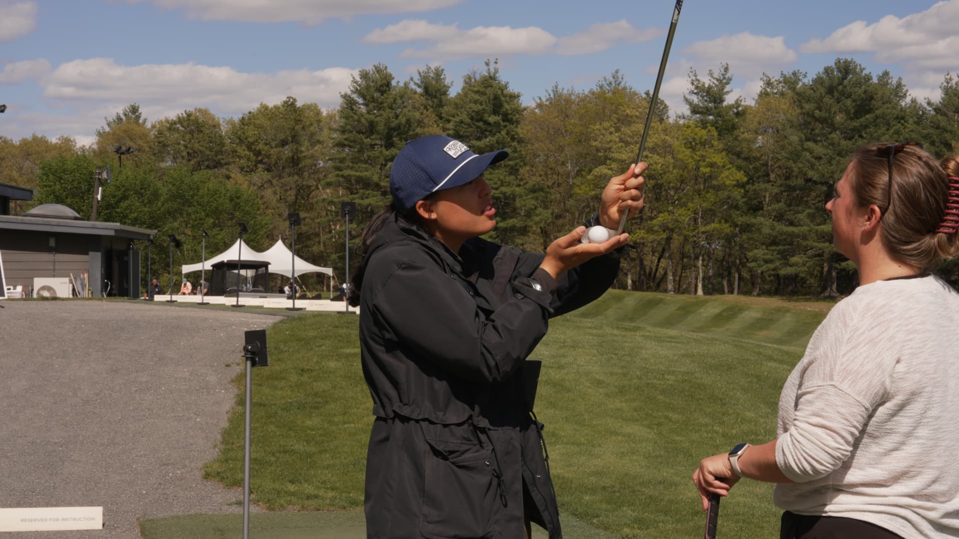 KOHR coach demonstrating grip and ball position with an adult clinic participant