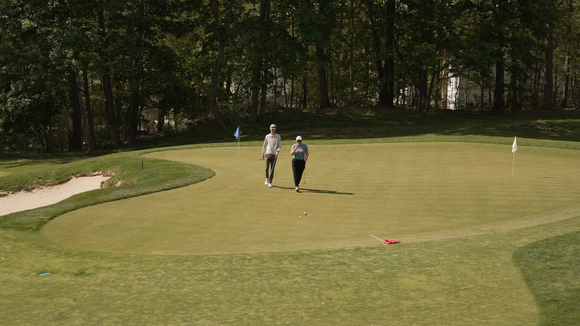 Two golfers walking the championship putting green at KOHR Golf