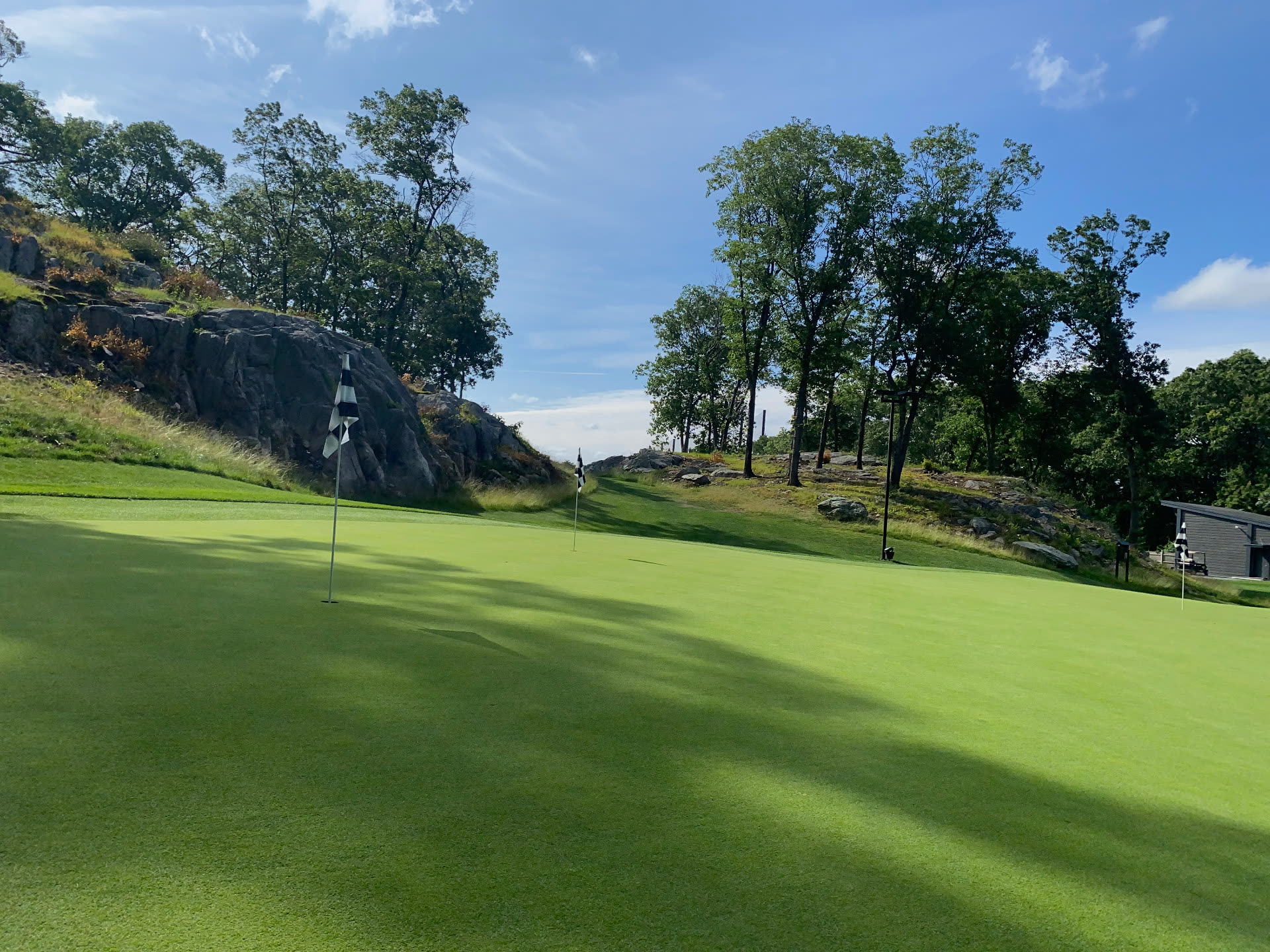 KOHR Golf short game practice green with championship flags and rocky ledges